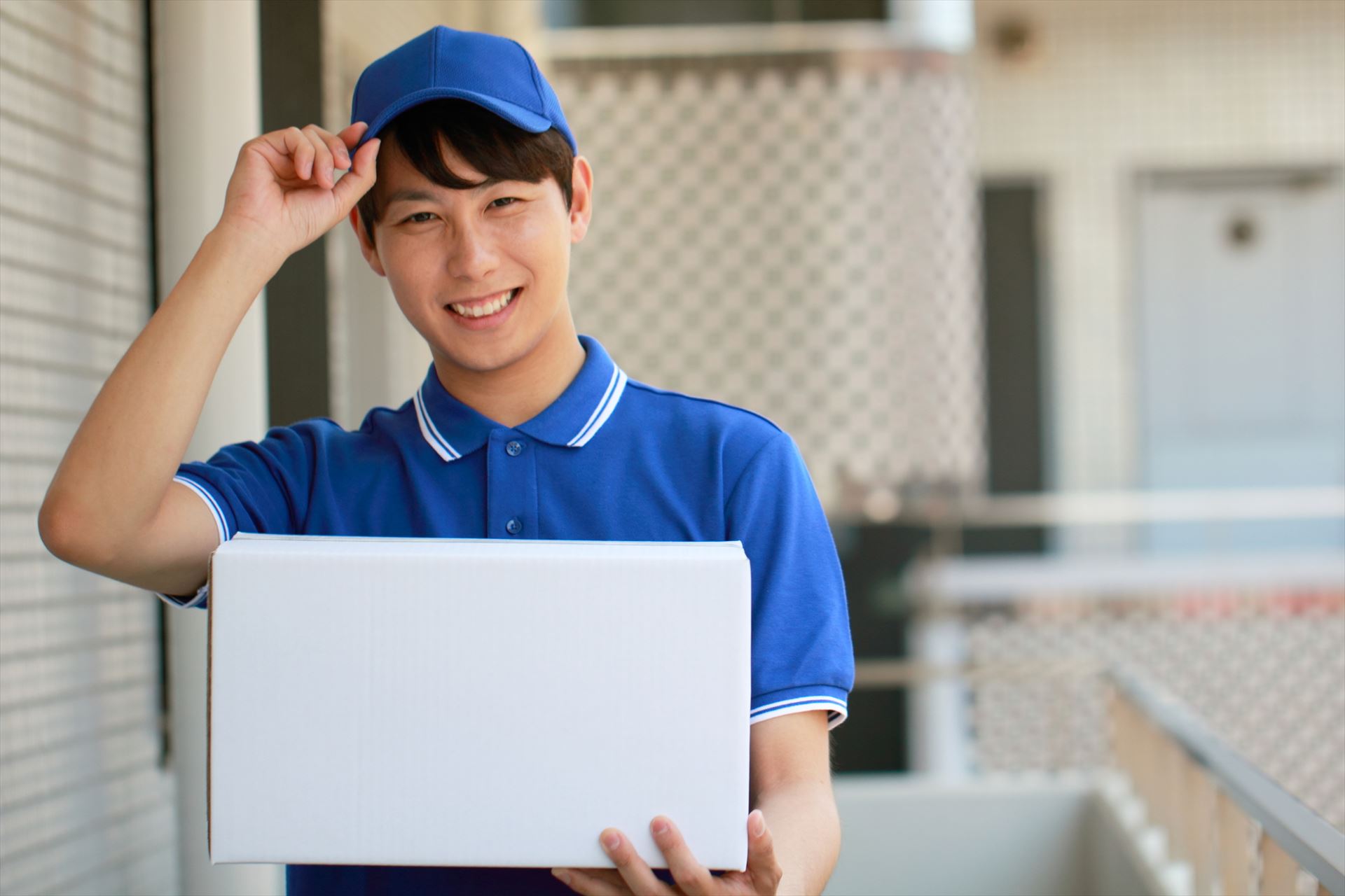 マンションで荷物を配達する男性スタッフ